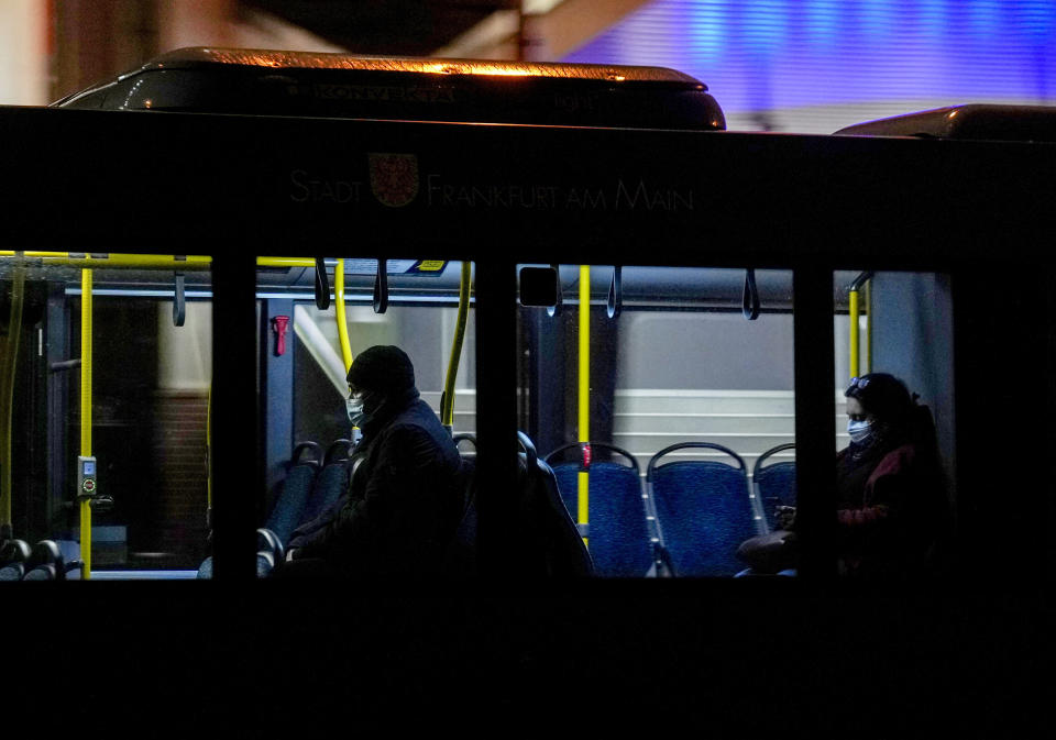 People wear face masks in a public bus in Frankfurt, Friday, Nov. 19, 2021. The government announced that the hospitalization rate will decide about further restrictions to avoid the outspread of the coronavirus. (AP Photo/Michael Probst)