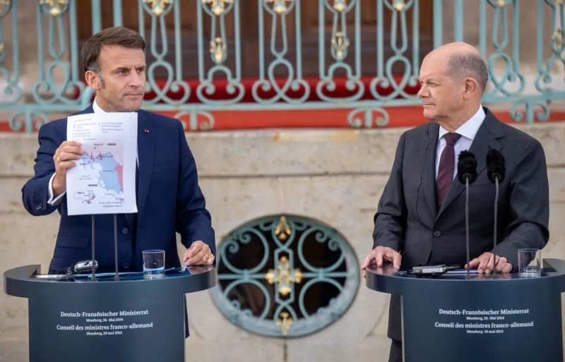 Germany's Chancellor Olaf Scholz (R) stands next to France's President Emmanuel Macron, at the press conference at the Franco-German Council of Ministers in front of Schloss Meseberg, the guest house of the German Government. Michael Kappeler/dpa