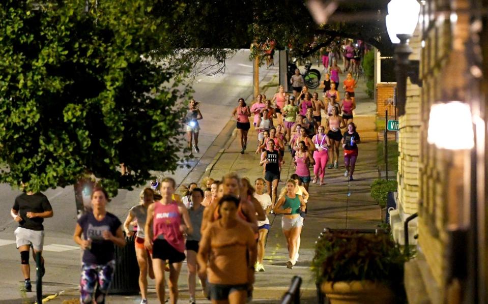 Runners head down the sidewalk past Fountain Square on Georgia Avenue during ‘Finish Eliza’s Run’ on Friday morning (AP)