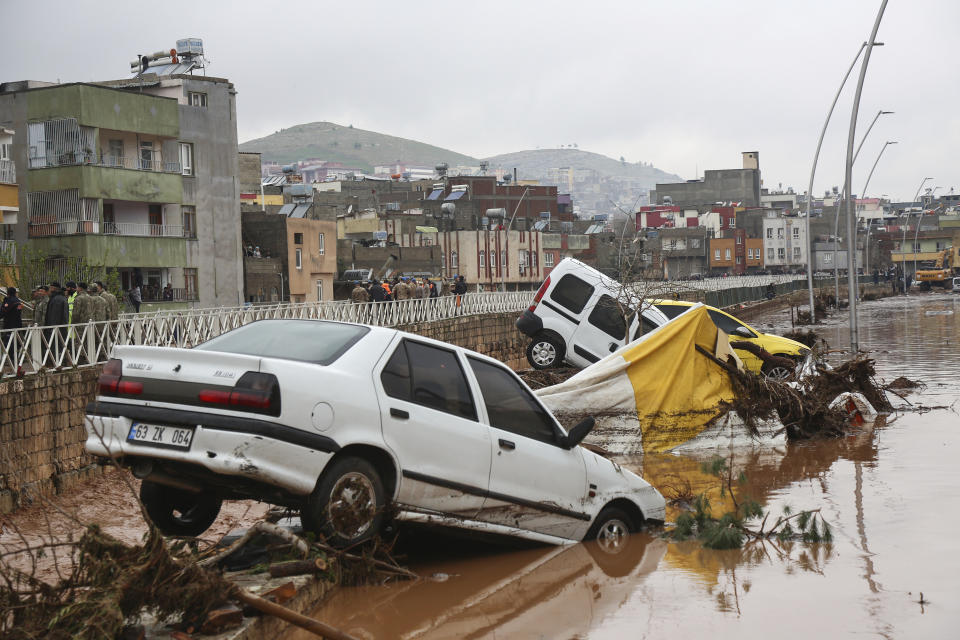 Cars and debris are scattered during floods after heavy rains in Sanliurfa, Turkey, Wednesday, March 15, 2023. Floods caused by torrential rains hit two provinces that were devastated by last month's earthquake, killing at least 10 people and increasing the misery for thousands who were left homeless, officials and media reports said Wednesday. At least five other people were reported missing. (Hakan Akgun/DIA via AP)