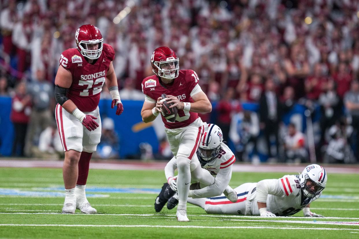 Dec 28, 2023; San Antonio, TX, USA; Oklahoma Sooners quarterback Jackson Arnold (10) avoids Arizona Wildcats defensive lineman Russell Davis II (99) in the first half at Alamodome. Mandatory Credit: Daniel Dunn-USA TODAY Sports ORG XMIT: IMAGN-715788 ORIG FILE ID: 20231228_tdc_da8_0376.JPG