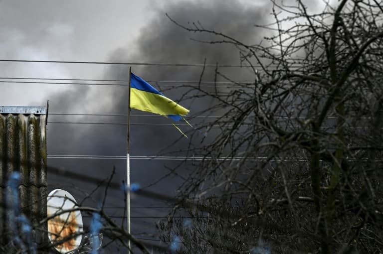 Un drapeau ukrainien dans les fumées de bombardement, à l'ouest de Kiev. PHOTO D'ILLUSTRATION - ARIS MESSINIS © 2019 AFP