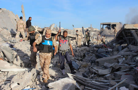 Fighters of Libyan forces allied with the U.N.-backed government walk through debris as they are close to securing last Islamic State holdouts in Sirte, Libya December 5, 2016. REUTERS/Ayman Sahely