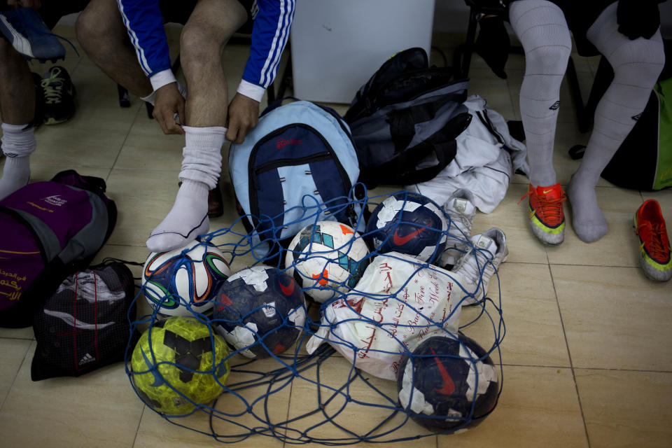 In this Friday, Feb. 7, 2014 photo, Wadi al-Nees players get ready before a league game at a stadium in Hebron, West Bank. Palestinian farmer Yousef Abu Hammad sired enough boys for a soccer team and the current roster of the Wadi al-Nees team includes six of Abu Hammad's sons, three grandsons and five other close relatives. Wadi al-Nees heads the West Bank's 12-team “premier league,'' consistently defeating richer clubs and believe their strong family bonds are a secret to their success. (AP Photo/Dusan Vranic)