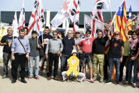 Demonstrators hold Sardinian and Catalonian, right, flags as they stand outside a court in Sassari, in Sardinia, Italy, Friday, Sept. 24, 2021. Former Catalan leader Carles Puigdemont, sought by Spain for a failed 2017 secession bid, on Friday awaited his opportunity to appear in court to argue against extradition, a day after Italian police detained him in Sardinia, an Italian island with strong Catalan cultural roots and its own independence movement. (AP Photo/Gloria Calvi)