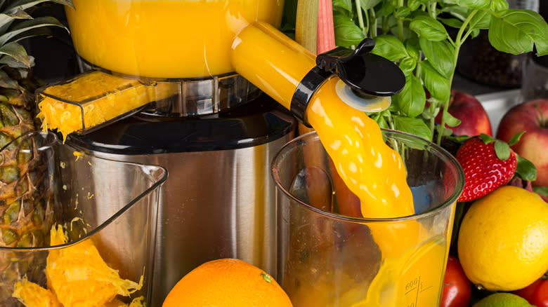 orange juice pouring from juicer