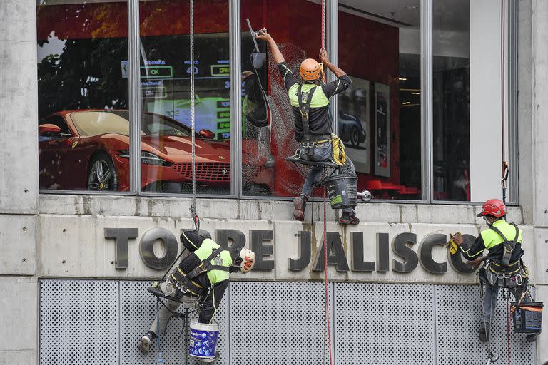 Trabajadores limpian los cristales de la concesionaria Ferrari en Caracas