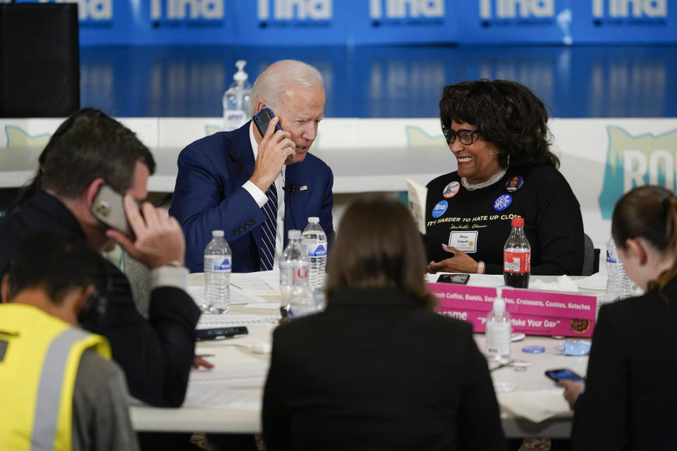 President Joe Biden works the phones during a grassroots volunteer event with the Oregon Democrats at the SEIU Local 49 in Portland, Ore. Friday, Oct. 14, 2022. Rosa Colquitt, Vice Chair Democratic Party of Oregon, is seated at right. (AP Photo/Carolyn Kaster)