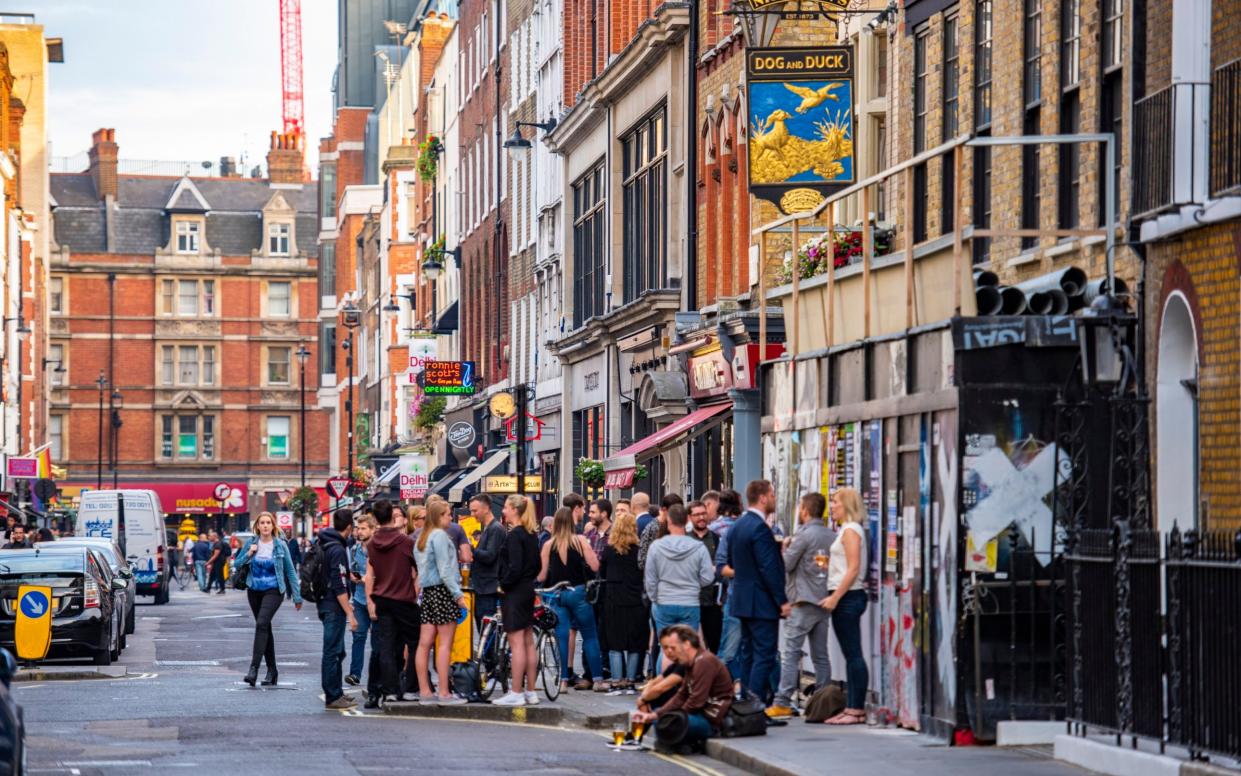 The Dog and Duck pub in Soho crowded outside with drinkers and tourists spilling onto the street