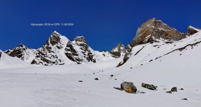 Snowy peak near a bigger, rocky one. 