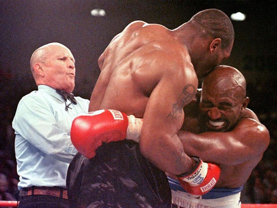 Mills Lane tries to separate Mike Tyson and Evander Holyfield after Tyson bit Holyfield’s ear in the third round of their WBA Heavyweight Championship Fight at the MGM Grand Garden Arena in 1997. (Jeff Haynes/AFP via Getty Images)