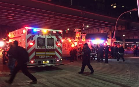 First responders carry a person to an ambulance after the crash in the East River - Credit: AP