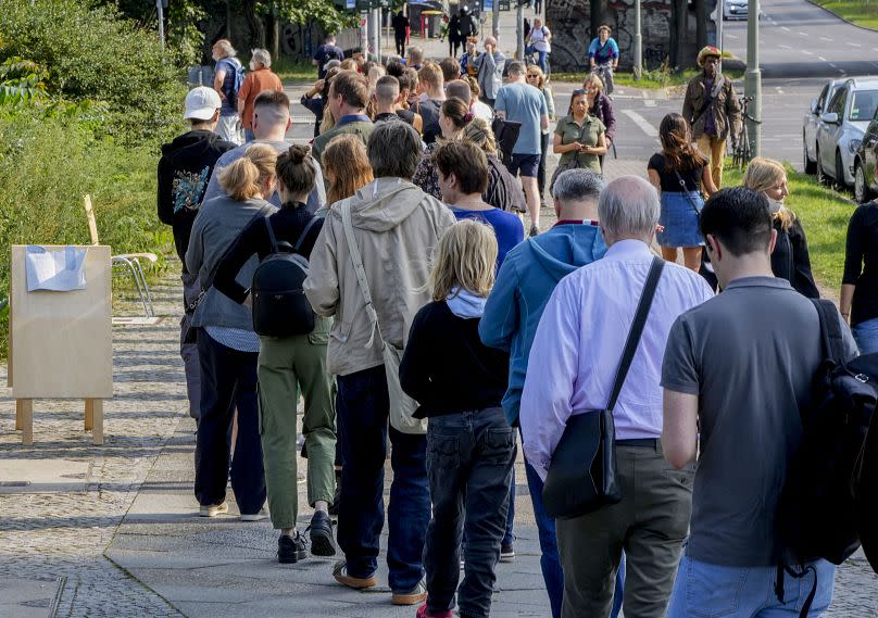 People queue in front of a polling station in the Moabit district of Berlin on election day