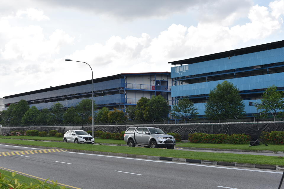 Vehicles pass the S11@Punggol foreign worker's dormitory compound, Friday, April 17, 2020 in Singapore. The city state is the latest Southeast Asian nation to surpass 5,000 COVID-19 cases, after more than 600 new cases were reported Friday. The health ministry said most of the new cases are foreign workers living in crowded dormitories. (AP Photo/YK Chan)