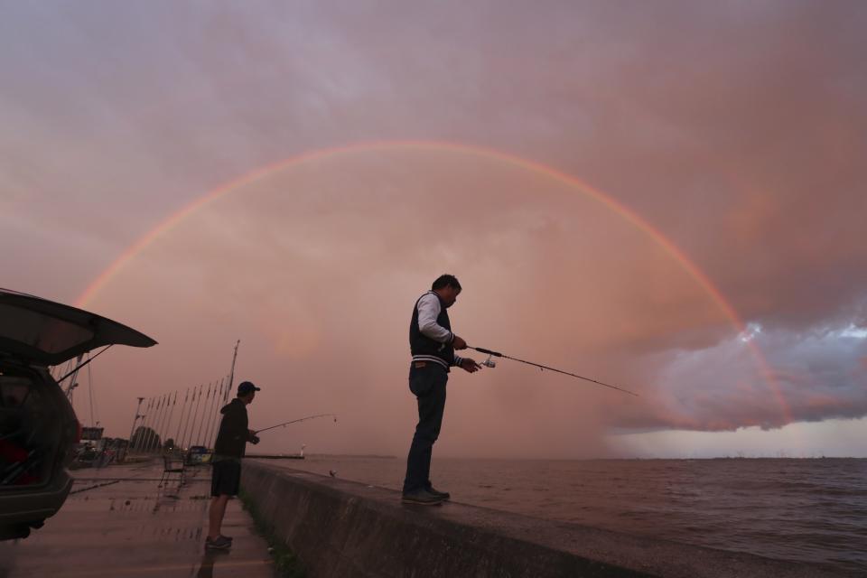 <p>Zwei Männer fischen am Hafen von Portsmouth im kanadischen Ontario vor der Kulisse eines Regenbogens. (Bild: Lars Hagberg/The Canadian Press via AP) </p>