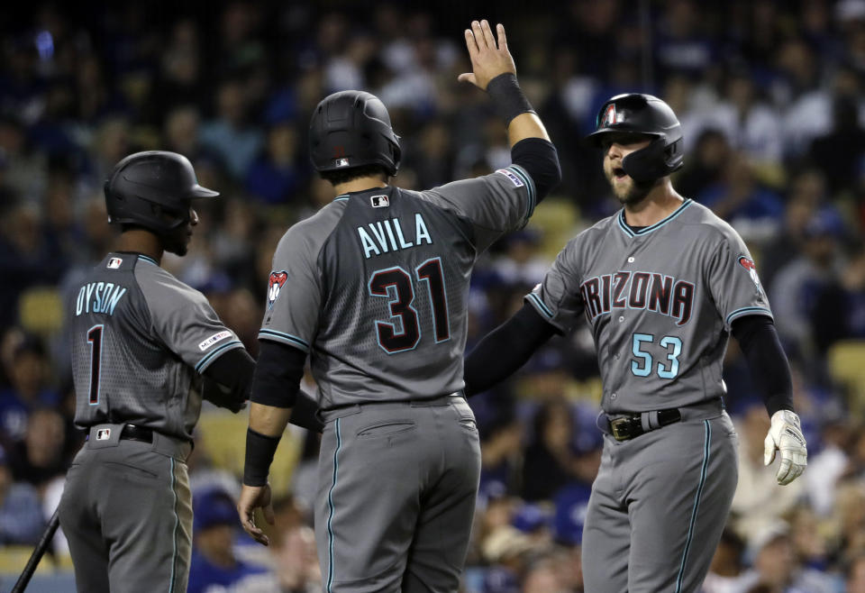 Arizona Diamondbacks' Christian Walker, right, is met at home plate by teammates Alex Avila and Jarrod Dyson after Walker's three-run home run against the Los Angeles Dodgers during the seventh inning of a baseball game Friday, March 29, 2019, in Los Angeles. (AP Photo/Marcio Jose Sanchez)