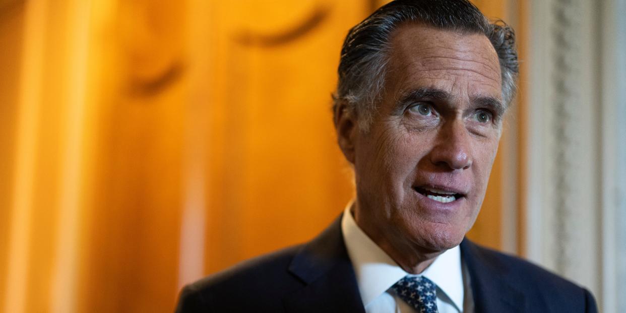 Mitt Romney stands outside the Senate Chambers.