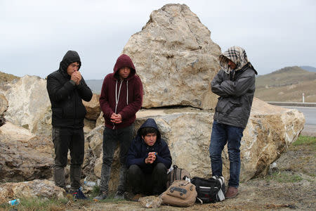 A group of Afghan migrants rest, during a break from their walk, on a main road, after crossing the Turkey-Iran border near Dogubayazit, Agri province, eastern Turkey, April 11, 2018. Picture taken April 11, 2018. REUTERS/Umit Bektas