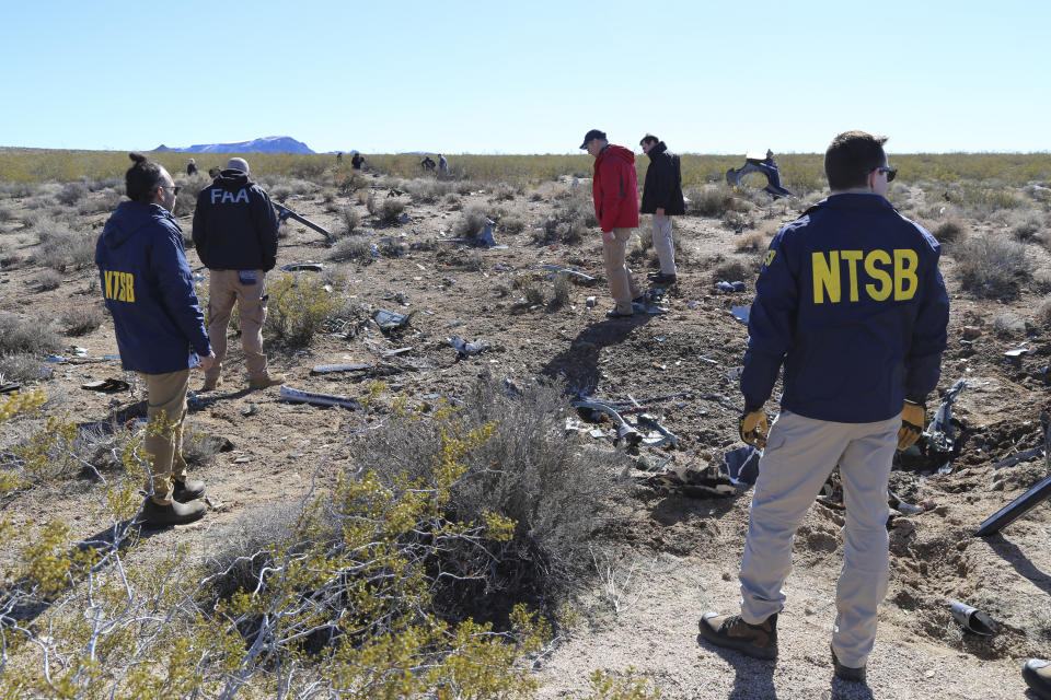 FILE - NTSB investigators survey the site of an Airbus Helicopters EC-130 on Sunday, Feb. 11, 2024, near Halloran Springs, Calif. The crash in the Mojave Desert killed, Herbert Wigwe, CEO of one of Nigeria's largest banks along with his wife and son. Investigators with the National Transportation Safety Board say, Friday, Feb. 23, 2024, the helicopter left a shallow crater when it crashed earlier this month in Southern California’s Mojave Desert. (Peter Knudson/NTSB via AP)