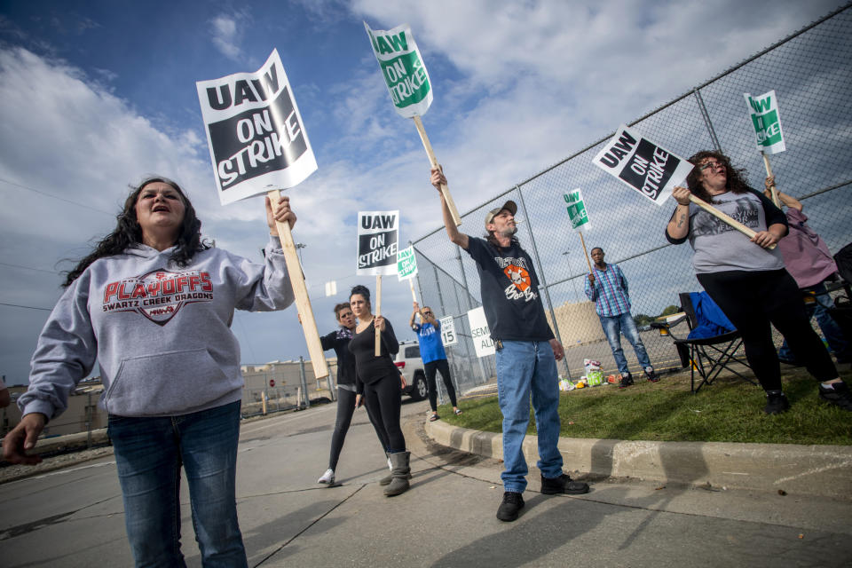 Roger Aylsworth, of Clio, center right, holds a sign sternly while demonstrating with other General Motors employees outside of the Flint Assembly Plant on Sunday, Sept. 15, 2019, in Flint, Mich. The United Auto Workers union says its contract negotiations with GM have broken down and its members will go on strike just before midnight on Sunday. (Jake May/The Flint Journal via AP)