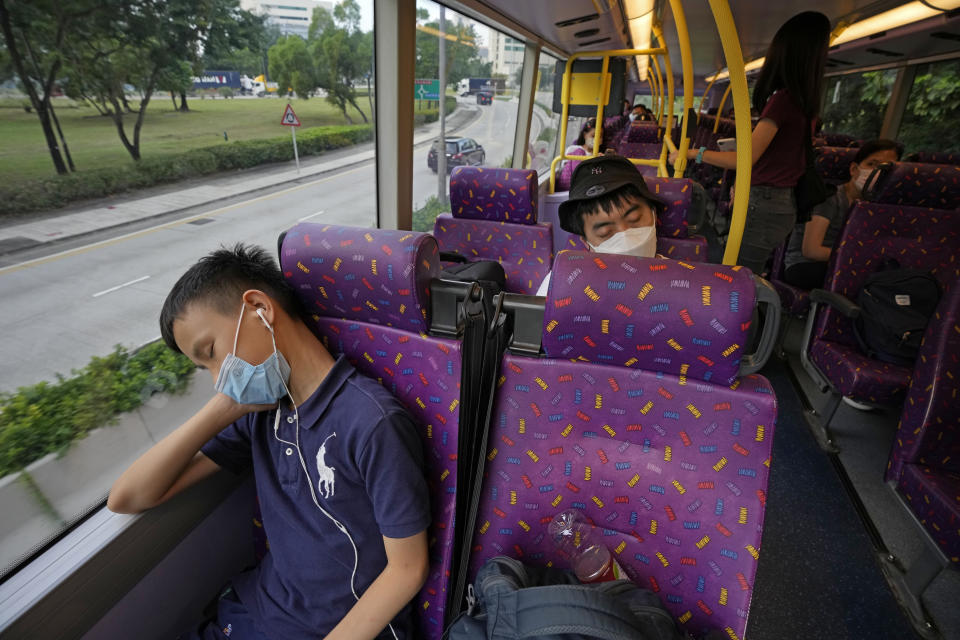 Passengers sleep on the upper deck of a double-decker bus in Hong Kong, Saturday, Oct. 16, 2021. Travel-starved, sleep-deprived residents might find a new Hong Kong bus tour to be a snooze. The 47-mile, five-hour ride on a double-decker bus around the territory is meant to appeal to people who are easily lulled asleep by long rides. (AP Photo/Kin Cheung)