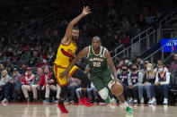 Milwaukee Bucks forward Khris Middleton (22) dribbles past Atlanta Hawks guard Timothe Luwawu-Cabarrot, left, during the first half of an NBA basketball game Monday, Jan. 17, 2022, in Atlanta. (AP Photo/Hakim Wright Sr.)