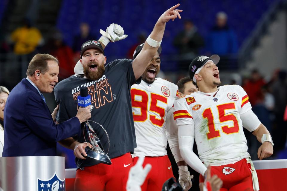 Kansas City Chiefs tight end Travis Kelce (M) celebrates with the Lamar Hunt trophy next to Chiefs defensive tackle Chris Jones (95) and Chiefs quarterback Patrick Mahomes (15) after the Chiefs' game against the Baltimore Ravens in the AFC championship game.