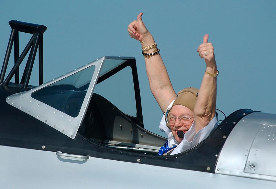 Maxine Flournoy gives thumbs up to a group of onlookers as she is taxied to the runway at Naval Air Station Kingsville in a C.A.F. PT-19 flown by Dan Duewall on May 21, 2004.