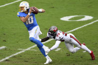 Los Angeles Chargers quarterback Justin Herbert (10) eludes a tackle by Tampa Bay Buccaneers free safety Jordan Whitehead (33) during the first half of an NFL football game Sunday, Oct. 4, 2020, in Tampa, Fla. (AP Photo/Jason Behnken)