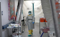 Medical student Engerlina Olivares walks through the Coronavirus Unit at United Memorial Medical Center, Monday, July 6, 2020, in Houston. Anyone seeing a COVID-19 patient is required to wear two sets of masks, gowns, gloves, shoe and head coverings, and a face shield. (AP Photo/David J. Phillip)