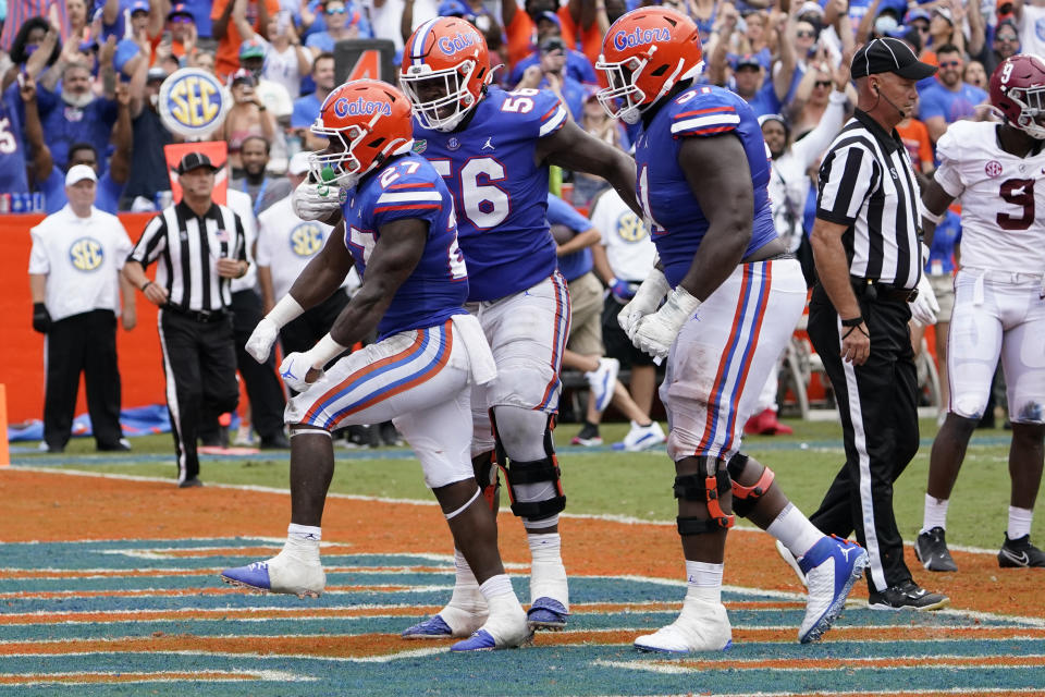 Florida running back Dameon Pierce, left, celebrates his touchdown run against Alabama with offensive lineman Jean Delance (56) and offensive lineman Stewart Reese, right, during the second half of an NCAA college football game, Saturday, Sept. 18, 2021, in Gainesville, Fla. (AP Photo/John Raoux)