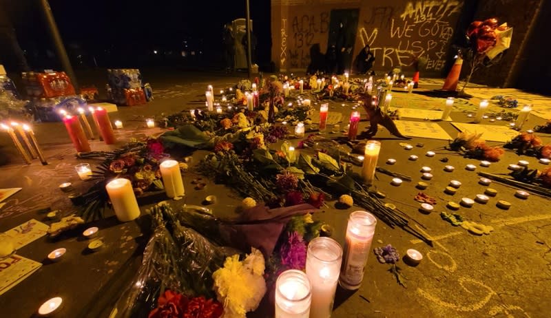 Candles and graffiti at the scene of a makeshift memorial in Portland's Normandale Park one day after a shooting left one woman dead and 5 others wounded, February 20, 2022 (KOIN)