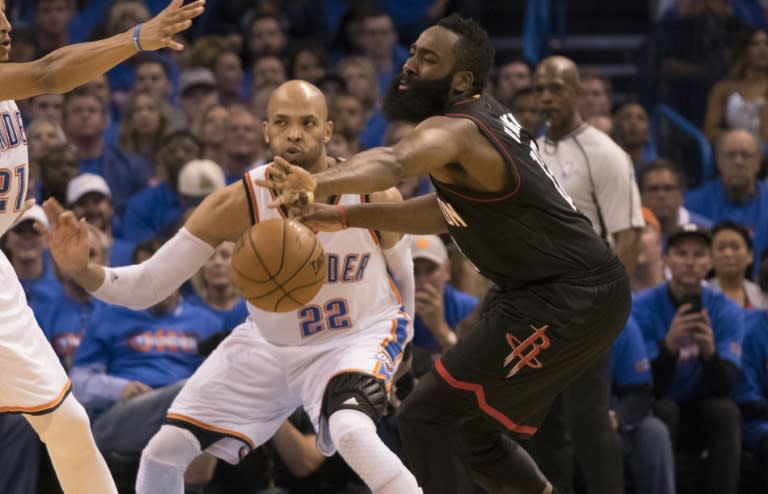 Taj Gibson (C) of the Oklahoma City Thunder forces James Harden of the Houston Rockets to pass the ball during Game Three in the Western Conference Quarterfinals