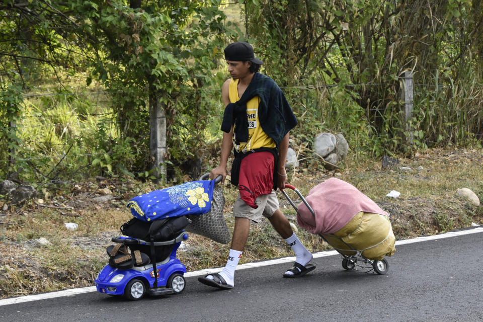 A migrant pushes and pulls his family's belongings as he walks north with a migrant caravan on the side of the highway in Villa Comaltitlan, Chiapas state, southern Mexico, Wednesday, Dec. 27, 2023. (AP Photo/Edgar H. Clemente)