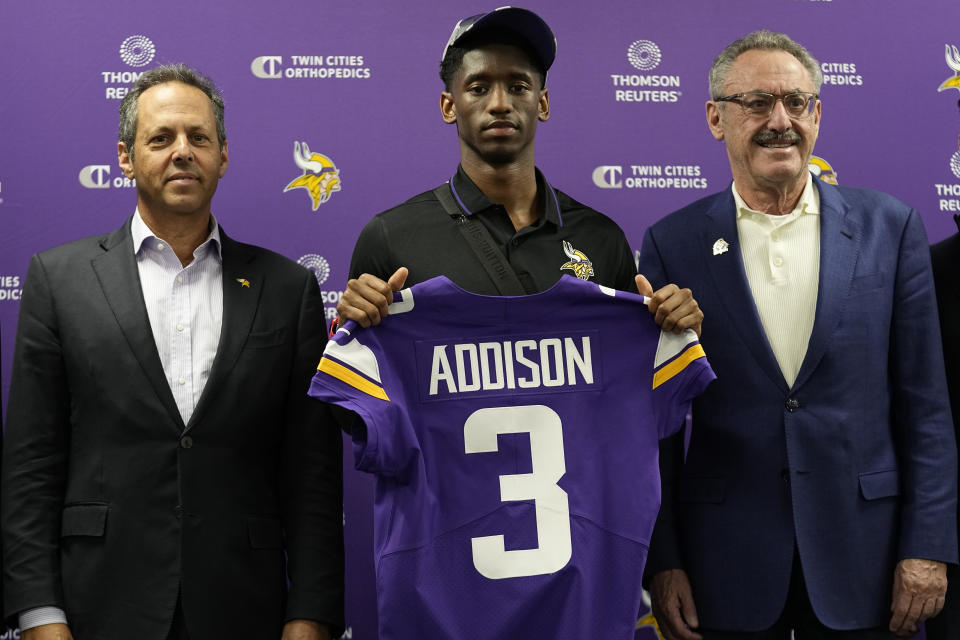 Minnesota Vikings owners Mark Wilf, left, and Zygi Wilf, right, pose for a photo with first-round draft pick Jordan Addison during an NFL football press conference in Eagan, Minn., Friday, April 28, 2023. (AP Photo/Abbie Parr)