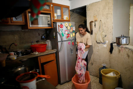 Jenny Montana, 38, washes a blanket at home in an apartment block in downtown Caracas, Venezuela, March 18, 2019. Montana, currently unemployed, lives with her daughter on the 9th floor of a building where the elevators have been damaged for a long time, according to neighbours. She says that she has to carry containers filled with 20 litres of water. "I remember once I had to carry up five containers in a day", she said. REUTERS/Carlos Garcia Rawlins