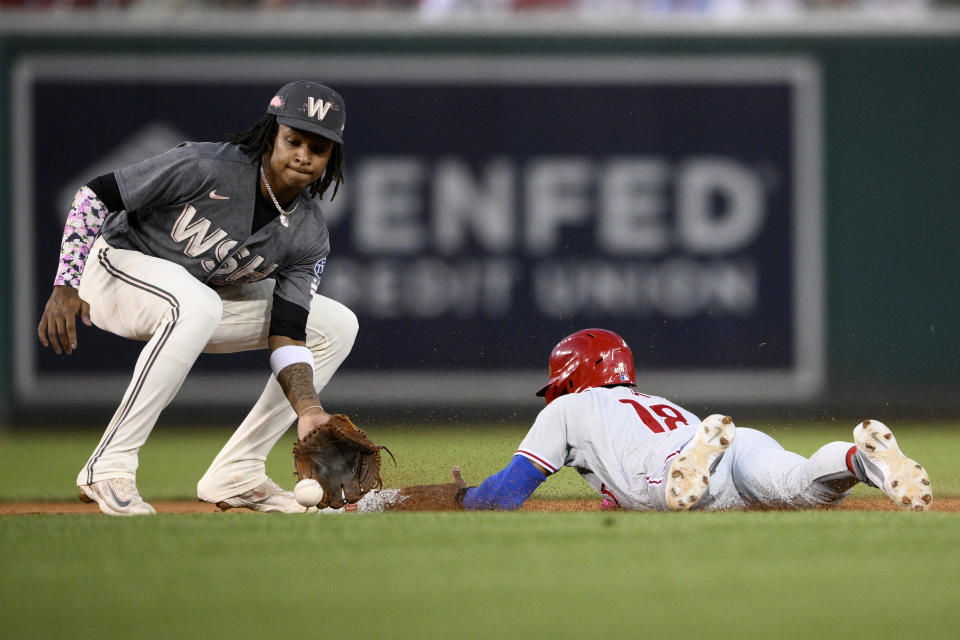 Philadelphia Phillies' Johan Rojas, right, steals second against Washington Nationals shortstop CJ Abrams during the fourth inning of a baseball game Friday, Aug. 18, 2023, in Washington. (AP Photo/Nick Wass)