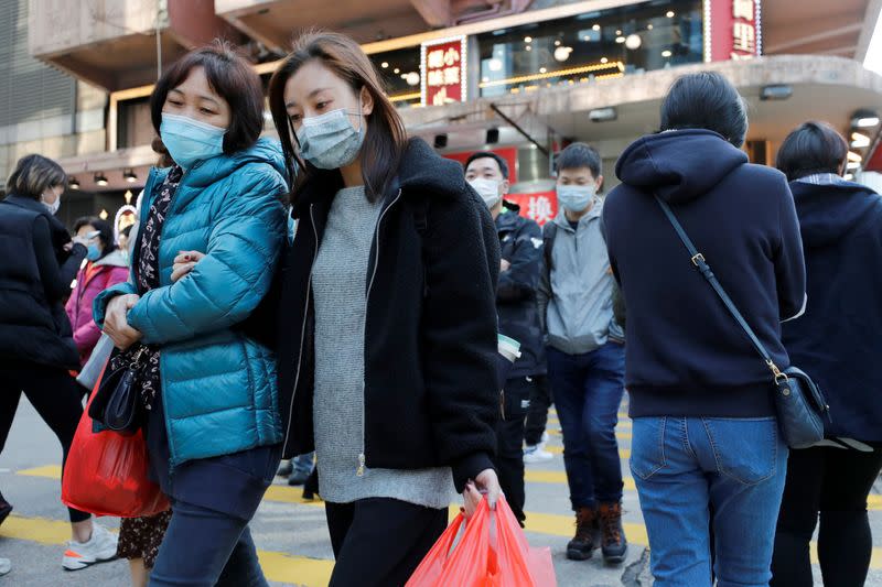 People wear protective masks as they walk a downtown street following the outbreak of the new coronavirus, in Hong Kong