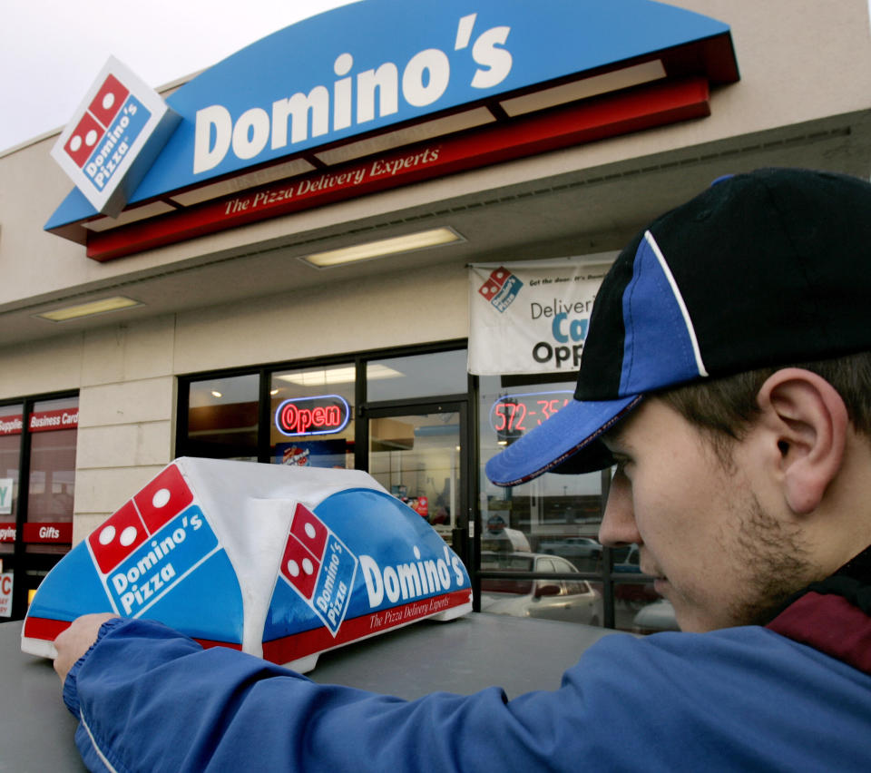 FILE - In this Feb. 21, 2007 file photo, Domino's Pizza delivery person Brandon Christensen plugs in the company sign atop his car in Sandy, Utah. The pizza delivery chain on Monday, June 16, 2014 plans to introduce a function on its mobile app that lets customers place orders by speaking with a computer-generated voice named "Dom."  (AP Photo/Douglas C. Pizac, File)