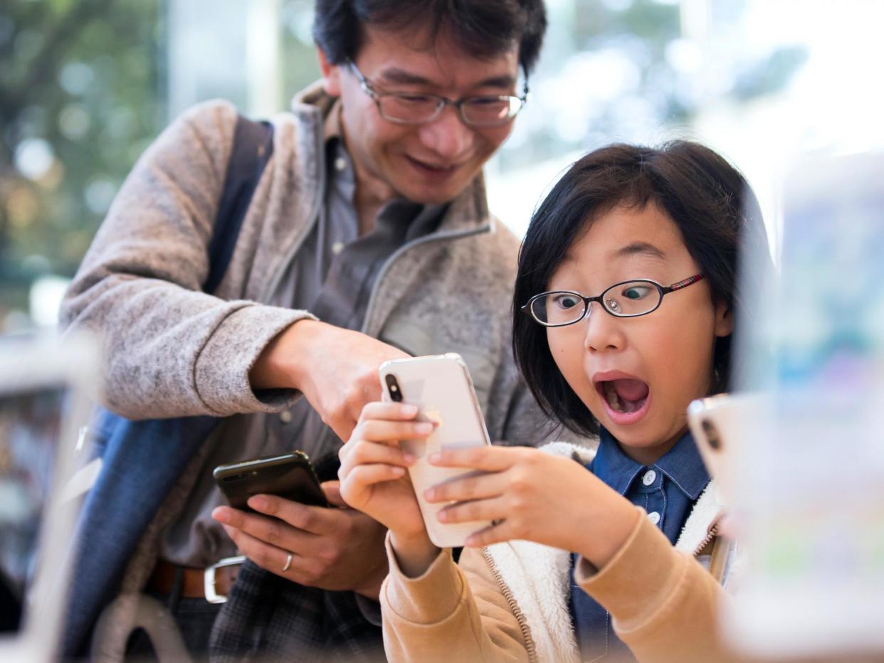 A girl reacts as she tries an iPhone X at the Apple Omotesando store on November 3, 2017 in Tokyo: Tomohiro Ohsumi/Getty Images