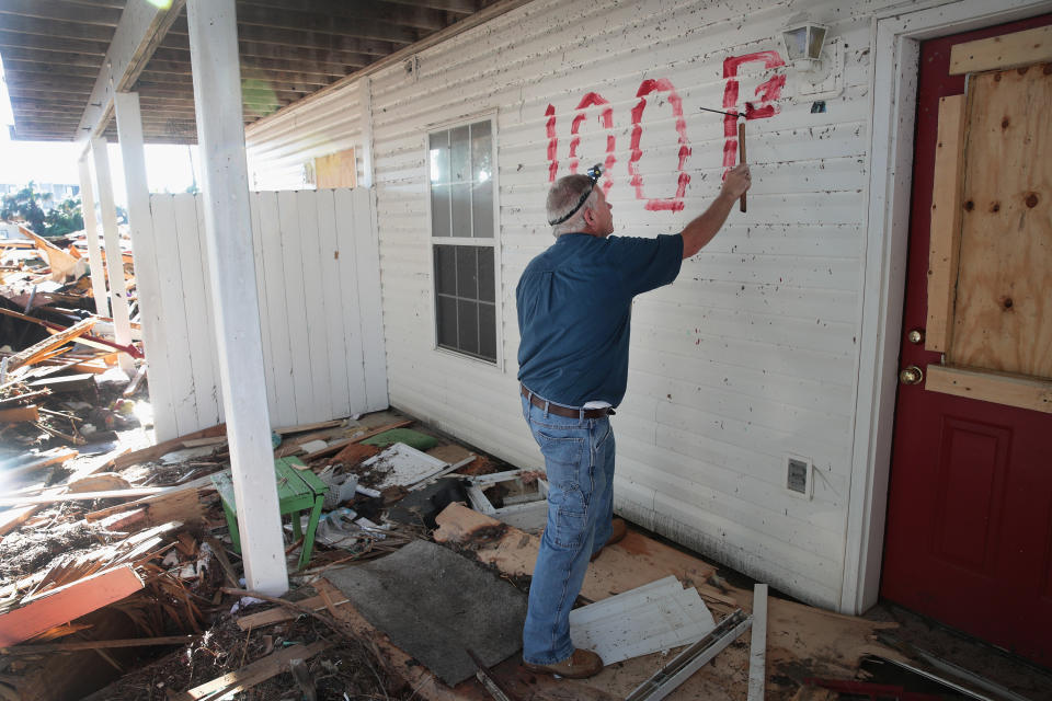 Denney Pate paints an address on a home to make it easier for the insurance adjuster and contractors to locate it after severe damage by Hurricane Michael on Oct. 16&nbsp;in Mexico Beach, Florida.