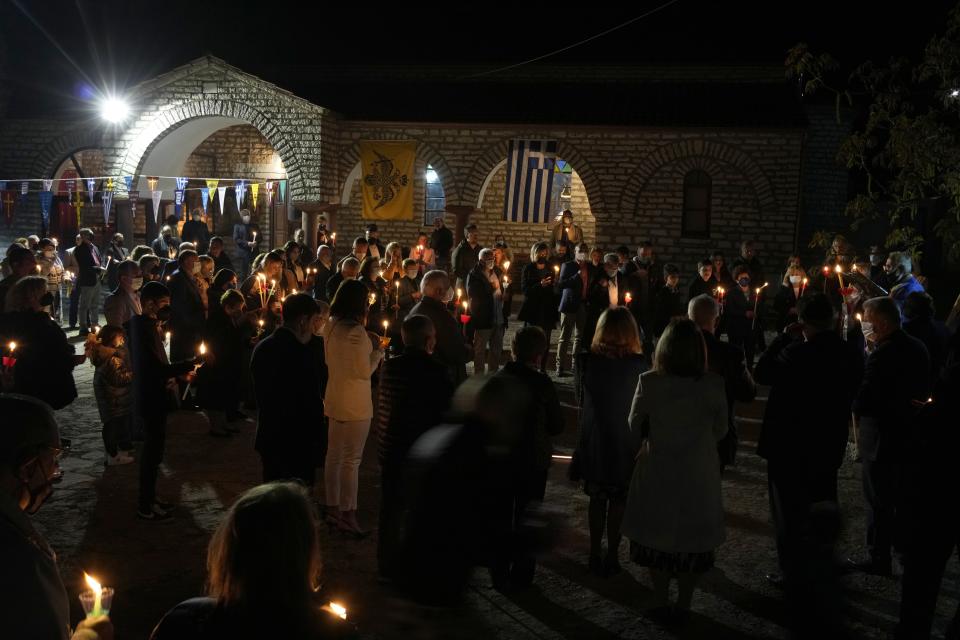 Faithful attend the Resurrection liturgy outside Agios Georgios church during celebrations for the Orthodox Easter in Myrodafni village, Epirus region, northwestern Greece, on Sunday, April 24, 2022. For the first time in three years, Greeks were able to celebrate Easter without the restrictions made necessary by the coronavirus pandemic. (AP Photo/Thanassis Stavrakis)