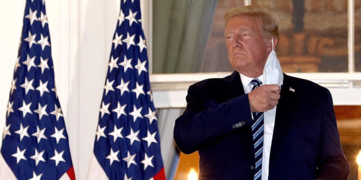 President Donald Trump removes his mask upon return to the White House from Walter Reed National Military Medical Center on October 05, 2020 in Washington, DC.