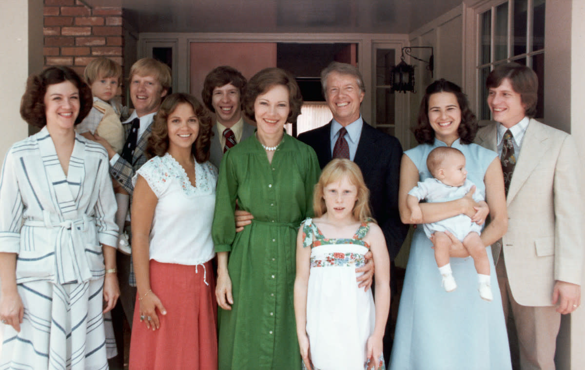 A portrait of President Jimmy Carter and his extended family. Left to right: Judy (Mrs. Jack Carter); Jason James Carter; Jack (John William Carter); Annette (Mrs. Jeff Carter); Jeff (Donnel Jeffrey Carter); First Lady Rosalynn Carter; daughter Amy Lynn Carter; President Carter; daughter-in law Caron Griffin Carter holding James Earl Carter IV; and son Chip (James Earl Carter III). 1977-1980. | Location: outdoors.<p>Historical/Getty Images</p>
