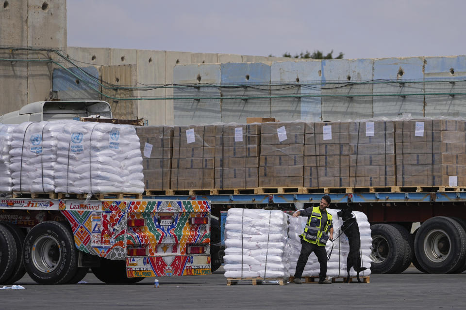 FILE - Trucks carrying humanitarian aid for the Gaza Strip pass through the inspection area at the Kerem Shalom Crossing in southern Israel, Thursday, March 14, 2024. Under heavy U.S. pressure, Israel has promised to ramp up aid to Gaza dramatically, saying last week it would open another cargo crossing and surge more trucks than ever before into the besieged enclave. But days later, there are few signs of those promises materializing and international officials say famine is fast approaching in hard-hit northern Gaza. (AP Photo/Ohad Zwigenberg, File)