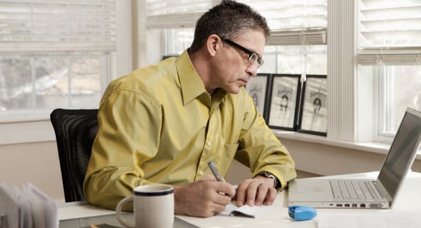 Hispanic man paying bills at desk