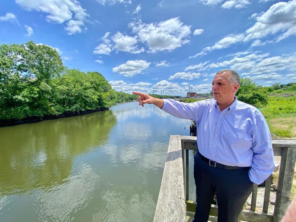 Pawtucket Mayor Don Grebien stands at the site of the proposed Tidewater Landing development on the Seekonk River just off downtown. The soccer stadium would go on 10 acres on the land to the right behind him.