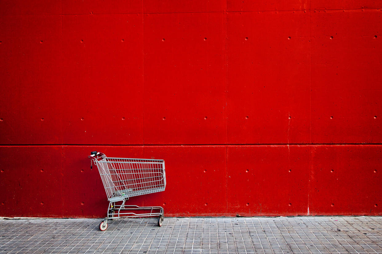 Empty shopping cart in front of a red wall Getty Images/Christian Adams