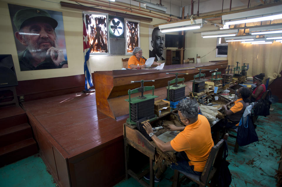 Odalys de la Caridad Lara Reyes entertains employees by reading to them as they work making cigars at the La Corona Tobacco factory in Havana, Cuba, Tuesday, June 29, 2021. She's one of a tiny band of tobacco factory readers, a job that dates to the 19th century and has become a unique part of Cuba's culture. (AP Photo/Ismael Francisco)