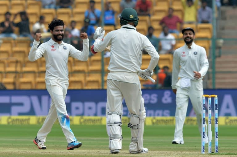 India's captain Virat Kohli (R) looks on as bowler Ravindra Jadeja celebrates the dismissal of Australian batsman Nathan Lyon (C) on the third day of their 2nd Test match, at The M. Chinnaswamy Stadium in Bangalore, on March 6, 2017